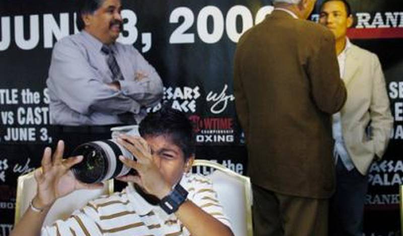 Сын Хосе Луиса Кастильо играется с объективом, в то время как Хосе Луис дает интервью