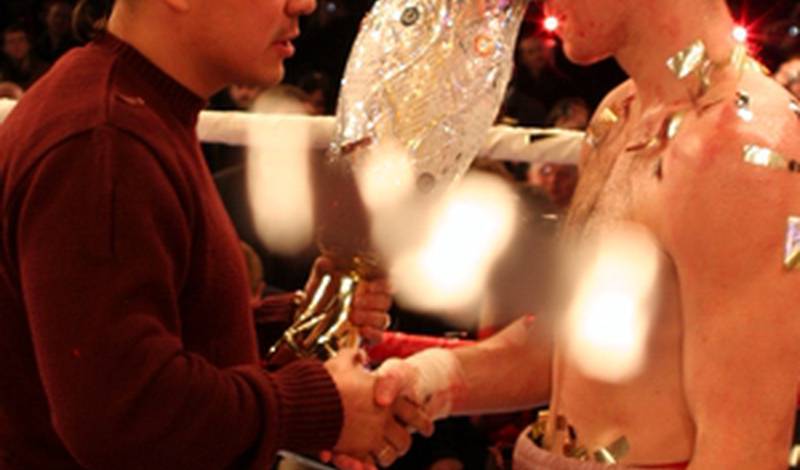 Костя Цзю вручает кубок лучшего боксера турнира Юрию Нужненко