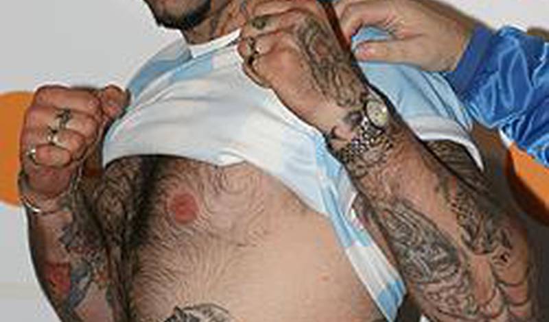Гонсало Омар Базиль демонстрирует на пресс-конференции свои татуировки