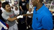 Мэнни Паккьяо и игрок NBA Рон Артест жмут друг другу руки во время открытой тренировки филиппинца в Лос-Анджелесе